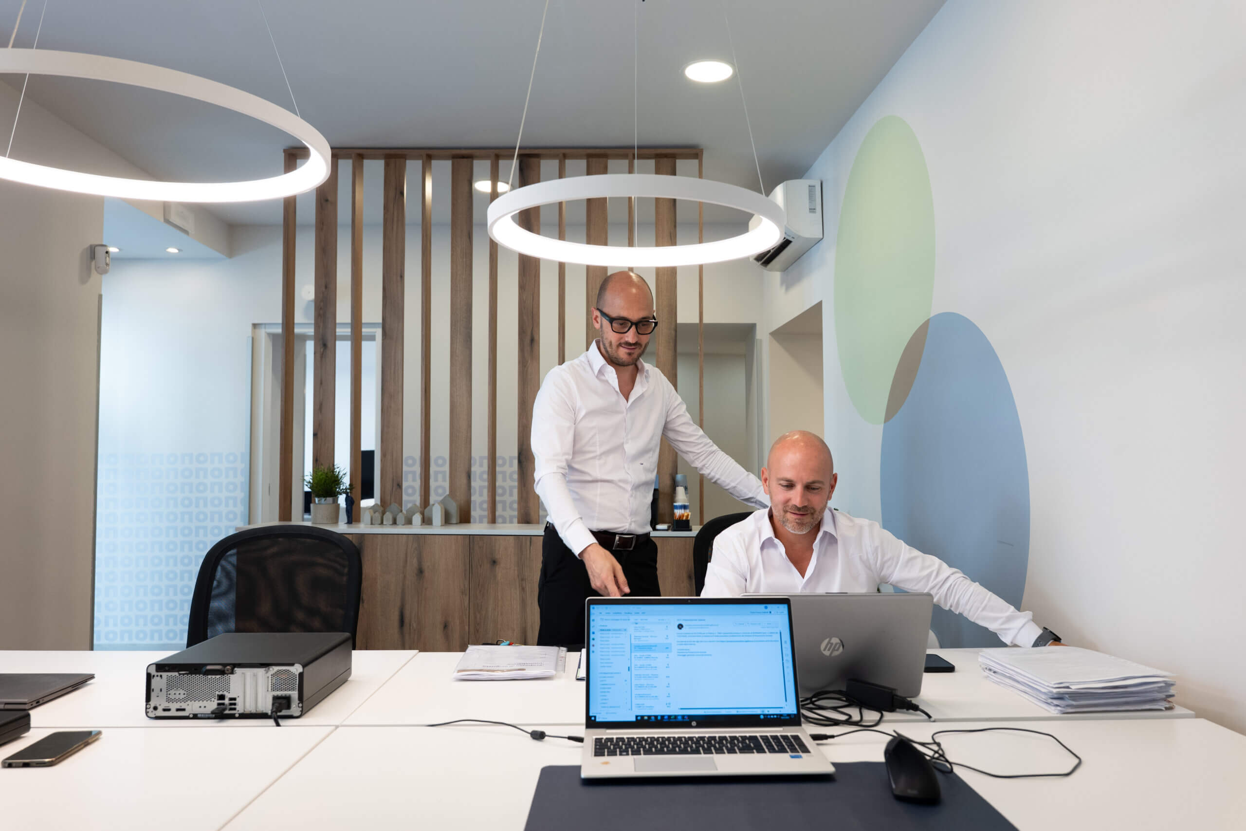 two men standing in an office